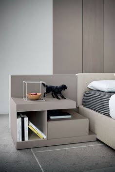 a bed with a dog on top of it next to a nightstand and bookcase