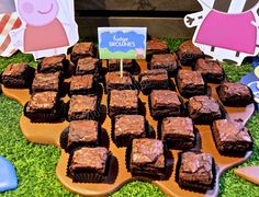 a table topped with chocolate brownies on top of a green field covered in grass