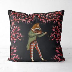 a decorative pillow with a painting of a fox playing the violin on it's side