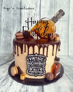 a birthday cake decorated with an old fashioned bottle and some liquor on it's side