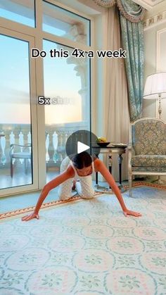 a woman laying on top of a rug in a living room next to a window