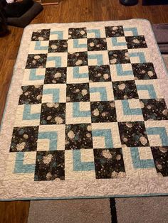 a black and white quilt on the floor