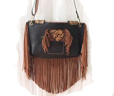 Reflecting western style, this western bag is the perfect accessory for those who love cowboy and rodeo themes. An elegant and stylish crossbody bag made of high quality leather material. Ideal for daily use, this bag is both practical and fashionable.  Ideal for festivals and outdoor events, this bag is made of durable black and brown leather. It offers comfortable use with its lightweight and useful design. It was also designed for those who embrace both Native American culture and Bohemian st Western Brown Bags For Rodeo, Western Style Brown Bags For Rodeo, Brown Rectangular Bag For Rodeo, Rectangular Brown Bag For Rodeo, Western Style Bags For Festivals, Western Brown Satchel Shoulder Bag, Western Style Crossbody Bags For Western-themed Events, Western Style Crossbody Shoulder Bag For Travel, Western Brown Bag With Fringe