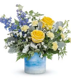 a blue vase with yellow roses and white flowers in it, on a white background