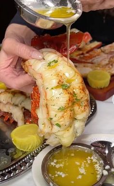 a person pouring sauce onto some food on a plate