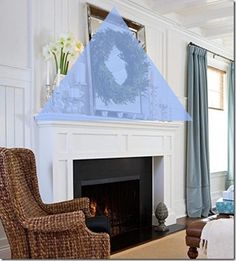 a living room filled with furniture and a fire place covered in blue sheer curtaines