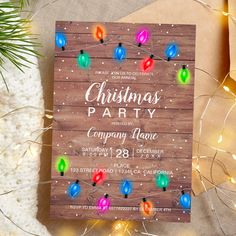 a wooden christmas party card with lights on it