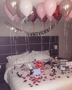 a bed topped with lots of balloons and confetti