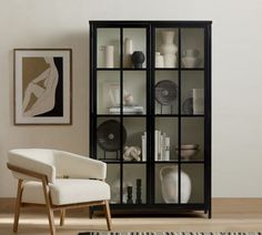 a white chair sitting in front of a black book case