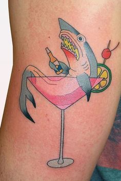 a shark in a cocktail glass tattoo on the leg