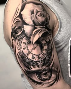 a man with a clock and rose tattoo on his arm is shown in black and white