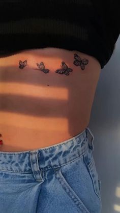 a woman's stomach with butterflies on it and the bottom part of her belly