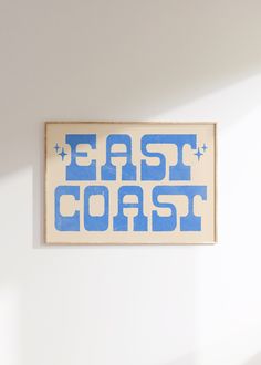 a blue and white sign that says east coast on the side of a wall in a room