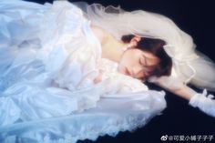 a woman in a wedding dress is sleeping