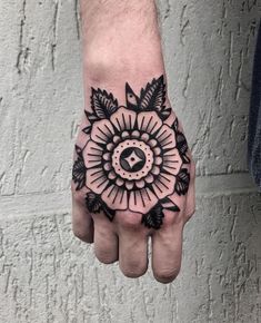 a hand with a black and white tattoo on it