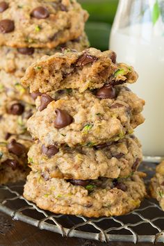 a stack of cookies sitting on top of a cooling rack next to a glass of milk