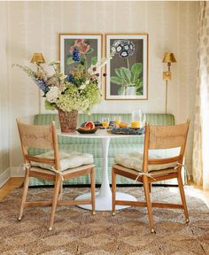 two chairs and a table with food on it in front of a green couches