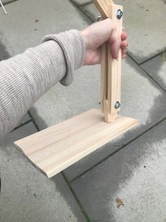 a person holding a piece of wood in their right hand and the other hand on top of it