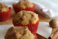 several muffins on a table with cinnamon sticks