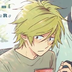 a young man with blonde hair is holding a cup and looking at his cell phone