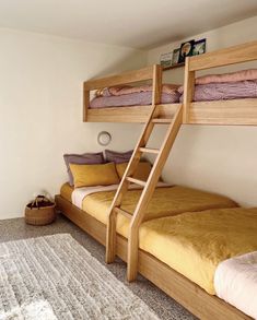 two bunk beds in a bedroom with yellow sheets and pillows on the bottom bunk bed