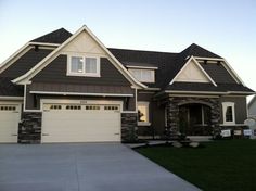 a large house with two garages in front of it