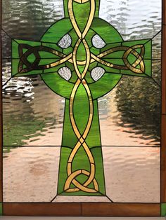 a stained glass window with a cross on it's side and an intricate design