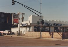 an old photo of a white castle restaurant on the corner of a street with traffic lights