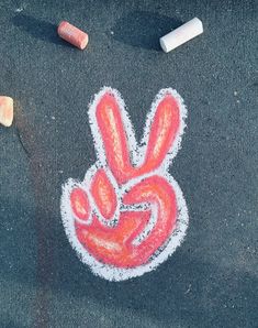 a chalk drawing of a peace sign and two crayons