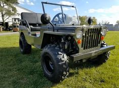 an army green jeep is parked in the grass