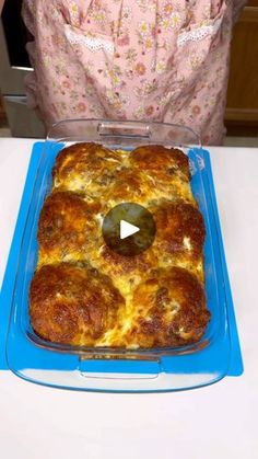 a casserole dish on a table with a person in the background looking at it