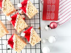 several pieces of cake sitting on top of a cooling rack next to christmas ornaments and a red book