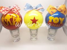 three small glass vases with bows on them are decorated like toy story characters, one is yellow and the other is red