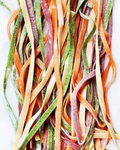 several strips of colorful vegetables on a white surface