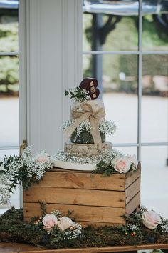 a three tiered cake sitting on top of a wooden box