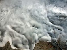 an aerial view of the surface of water with white foam on it's surface