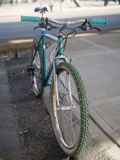 a bicycle parked on the side of a street next to a curb with no traffic