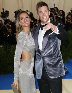 a man in a tuxedo standing next to a woman wearing a silver dress