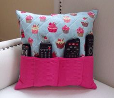 a pillow with remotes and cupcakes on it is sitting on a chair