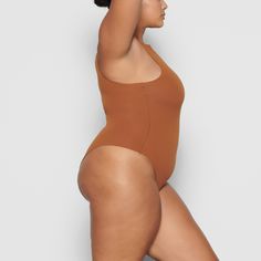 Fits Everybody High Neck Bodysuit | Copper — A classic, everyday style, this High Neck Bodysuit provides coverage and supportive stretch that hugs your body. This bodysuit is the perfect base layer and features a high cut leg opening and thong back that remains invisible under clothing. Solid High Cut Bodysuit For Swimming, High Cut High Stretch Bodysuit For Swimming, High Cut Solid Leotard With Lined Body, High Stretch Smoothing One-piece Bodysuit, High Cut Seamless Bodysuit For Swimming, Solid Compressive One-piece Bodysuit, Second-skin Seamless One-piece Bodysuit, Second-skin Smoothing Bodysuit For Swimming, Smoothing Second-skin Bodysuit For Swimming