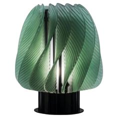 a green lamp that is on top of a black stand