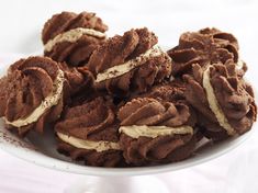 a white plate topped with chocolate cookies covered in frosting