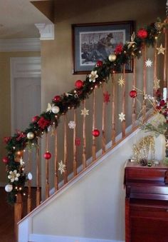 christmas decorations on the banisters and stairs in a home decorated with red, white and gold ornaments