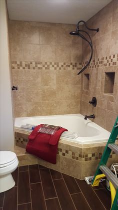 a bathroom with tiled walls and brown flooring