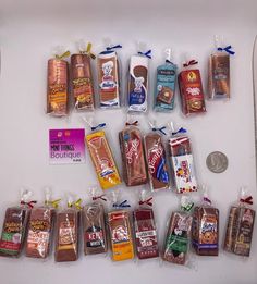 an assortment of chocolates and candy bars are displayed on a white surface with a penny