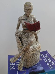 a book sculpture sitting on top of a pile of books