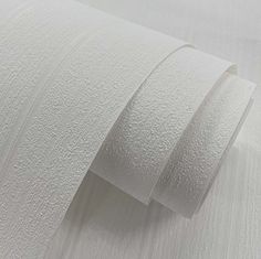 two rolls of white paper sitting on top of each other