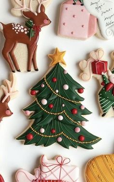 decorated christmas cookies are arranged on a white surface, including a tree and other decorations