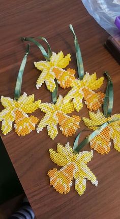 four pieces of beaded autumn leaves on a table