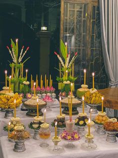 a table topped with lots of different types of cakes and desserts covered in candles